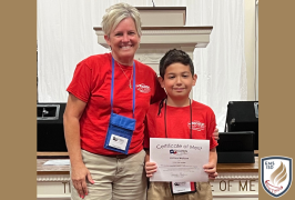  Woman and boy standing next to each other. the boy is holding a certificate.